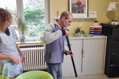 Une femme observe un homme en train de passer l'aspirateur - Agrandir l'image 2 sur 3, fenêtre modale