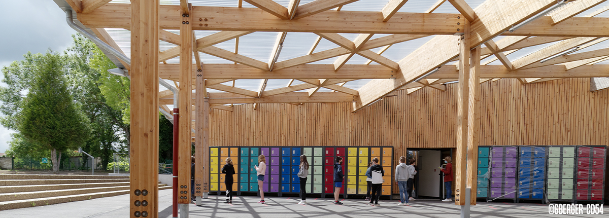 Collège avec structure moderne en bois, casiers colorés alignés et élèves interagissant avec eux, sous une toiture en treillis et un ciel nuageux